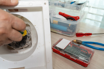 Close-up hand of man repairing or Fixing the exhaust fan.