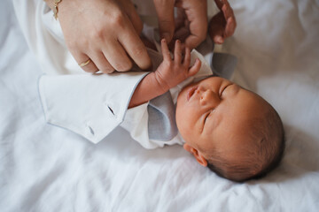 Newborn baby being cared for by adult hands