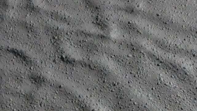 op down view of an abstract gray surface with grainy texture and smooth flowing shadow ripples, creating a minimalist artistic background