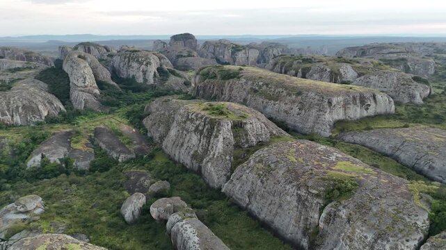 Cinematic aerial perspective of the ancient Pedras Negras de Pungo Andongo monoliths in the Malanje Province, Angola, Africa, capturing the unique geological textures of the black rocks