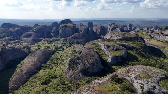 Stunning high-altitude drone panorama of the ancient Pedras Negras de Pungo Andongo monoliths in Malanje Province, Angola, Africa, set against a vast green horizon