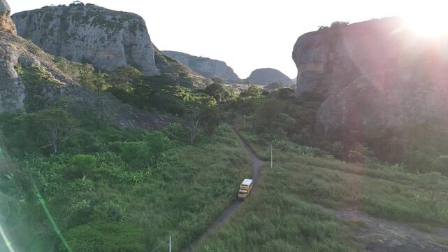 Atmospheric aerial shot of the Pedras Negras de Pungo Andongo monoliths in Malanje Province, Angola, Africa, with a camper van truck overloading driving in a narrowed off road path