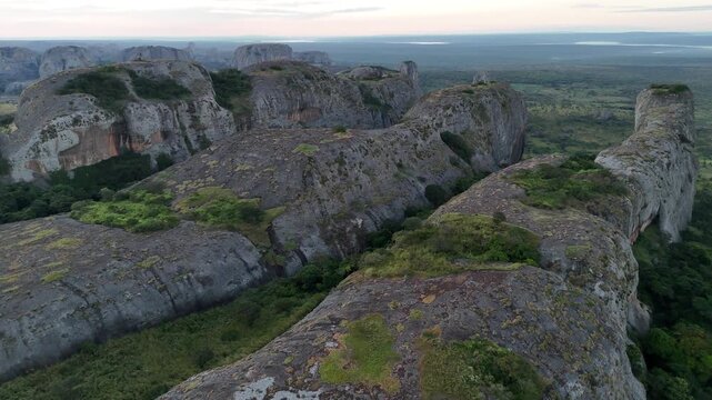 Dynamic low-altitude aerial journey through the Pedras Negras de Pungo Andongo rock system in Malanje Province, Angola, Africa at sunset