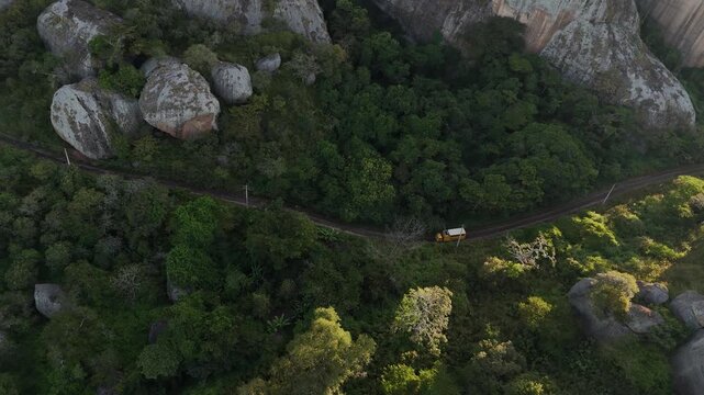 drone flight over the rugged and ancient topography of the Pungo Andongo region, featuring spectacular black rock formations, Angola Africa aerial top down following a track van overloading expedition