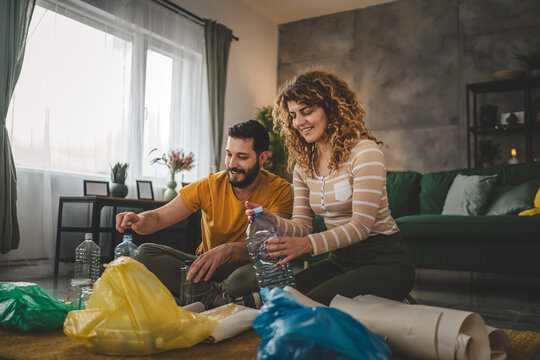 husband and wife recycle at home sorting waste plastic paper and glass