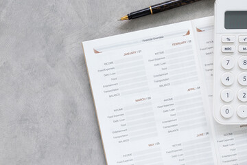Financial year plan 2026 concept with calculator, pen, and notebook on grey desk. Minimalist business workspace for budget planning, investment goals, and accounting with top view copy space.