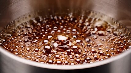A captivating extreme closeup reveals the vigorous boiling of a rich dark liquid possibly coffee or a sweet syrup showcasing countless effervescent bubbles rapidly forming expanding and bursting on t.