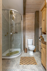 Cozy rustic bathroom with glass shower cabin and wooden walls