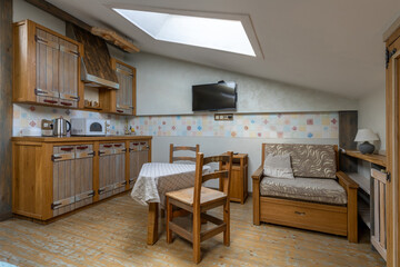 Rustic attic studio interior with kitchen and lounge area