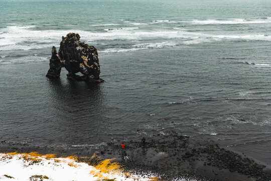 View of Hvitserkur sea stack rises dramatically from the dark, turbulent waters under a moody sky, its craggy form a testament to nature's power, Blonduos, Vatnsnes peninsula, North Iceland, Iceland.