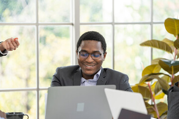 black business man smiling while working at laptop