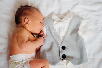 Baby sleeps next to suit for special event