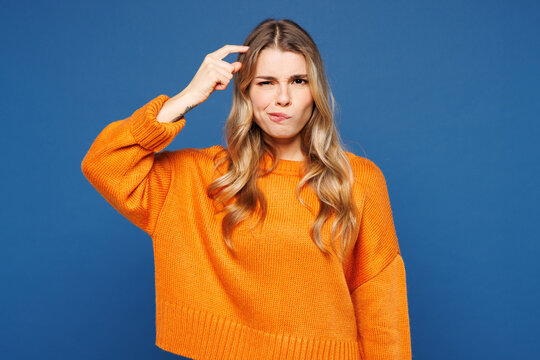 Young sad frustrated mistaken thoughtful woman she wears yellow sweater casual clothes put hand on head look aside on area mockup isolated on plain blue background studio portrait. Lifestyle concept.