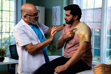 Indian physiotherapist with happy patient showing thumbs up after shoulder pain treatment