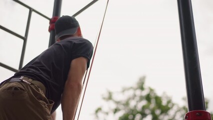 Man Plans Workout, Caucasian Male Evaluates Calisthenics Gear Before Starting Routine, Man Of Caucasian Ethnicity Examines Calisthenics Apparatus While Contemplating His Next Exercise Move