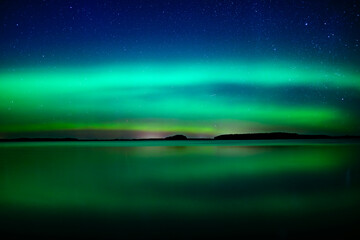 Northern lights dancing over calm lake in north of Sweden.