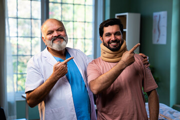 Indian physiotherapist treating young patient with neck and shoulder pain in clinic