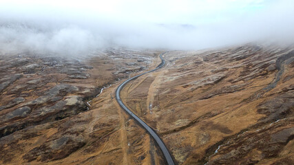 Aerial View of Remote Icelandic Valley with Meandering River and Mountain Road Surrounded by Mist and Volcanic Highlands