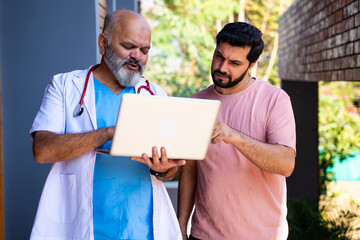 Indian doctor patient discuss case outdoors while reviewing medical details in nature