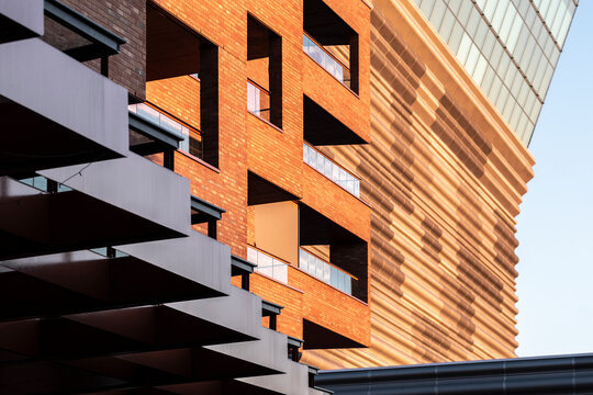 Modern urban architecture with a brick building facade where geometry and pattern meet deep shadow and warm sunlight for minimal abstract texture