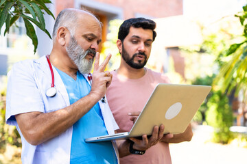 Indian doctor patient discuss case outdoors while reviewing medical details in nature