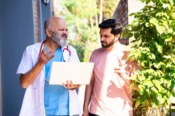 Indian doctor patient discuss case outdoors while reviewing medical details in nature