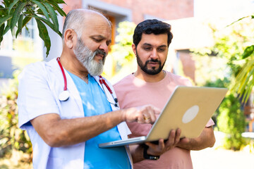 Indian doctor patient discuss case outdoors while reviewing medical details in nature