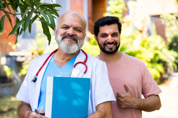 Indian doctor patient discuss case outdoors while reviewing medical details in nature