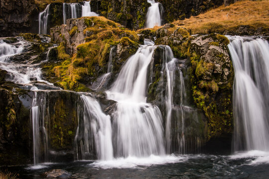 View of cascading waterfalls thunder down moss-covered rocks, creating a mesmerizing display of nature's raw beauty, Grundarfjordur, West Iceland, Iceland.