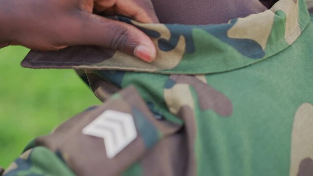 Military Member Checks Uniform Meticulously, Service Member Properly Adjusts Gear Before Inspection, Military Individual Meticulously Prepares Uniform And Gear Prior To Official Assessment Outdoors