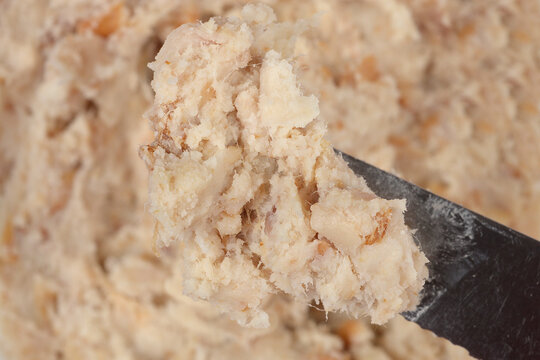 A close up shot of traditional zaseka pork fat spread with minced meat being served on a metal knife