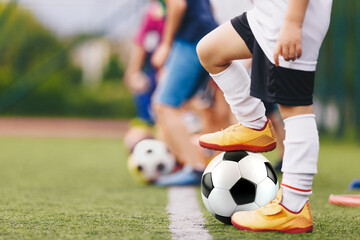 Football soccer training game for children. Kids playing with soccer balls on grass pitch