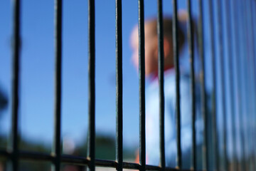 Problems at school for girls and adolescents. Conceptual image of a girl out of focus on the other side of a school fence