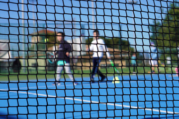 Faceless image of a child playing tennis while training during an extracurricular activity