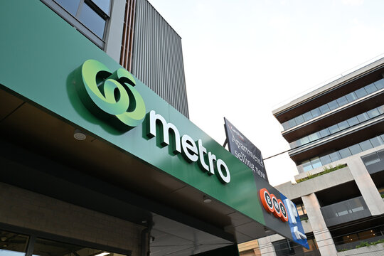 Woolworths Metro signage above the entrance to one of their supermarkets, with Gary Peer real estate signage above that