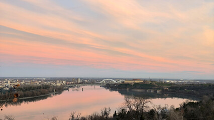 colorful sky at sunrise with dramatic clouds over the Danube river with view at Petrovaradin Fortress