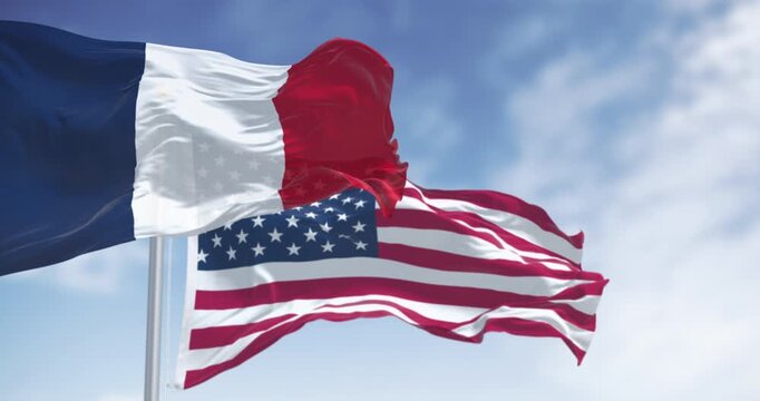 National flags of France and USA waving in the wind on a clear day