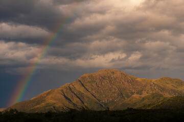 Arco&iacute;ris sobre picos monta&ntilde;osos durante la hora dorada, concepto de esperanza y naturaleza.