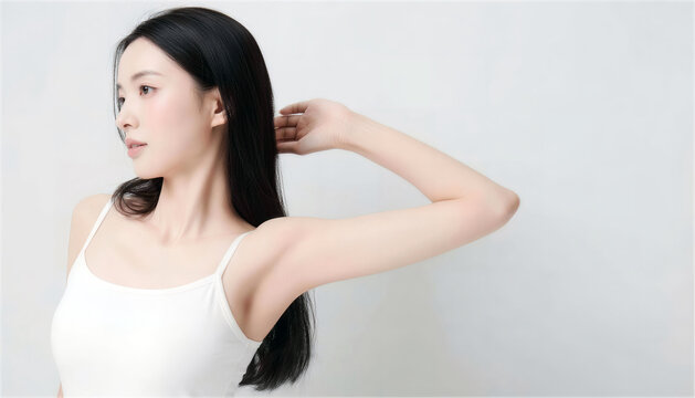 髪に手を添えて脇を見せる黒髪ロングヘアの日本人女性