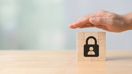 hand protecting wooden block with padlock symbol