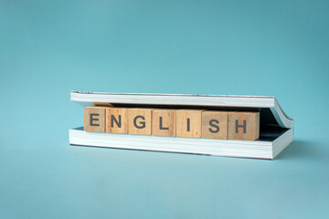 Word English on wooden blocks between pages of a book