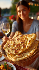 Woman enjoying a meal with wine and delicious flatbread at an outdoor restaurant.