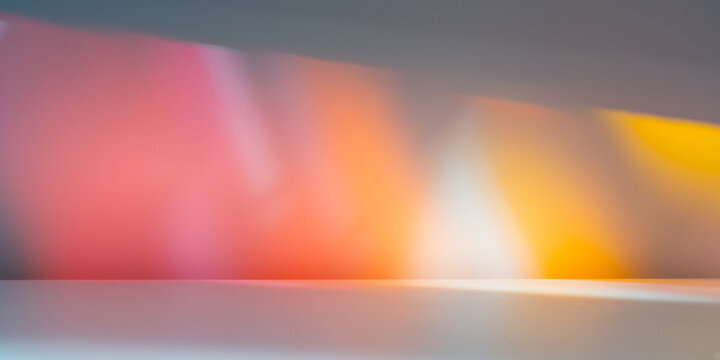 Stained glass light on wall. Light background for product presentation with colorful reflections and shadows on wall.