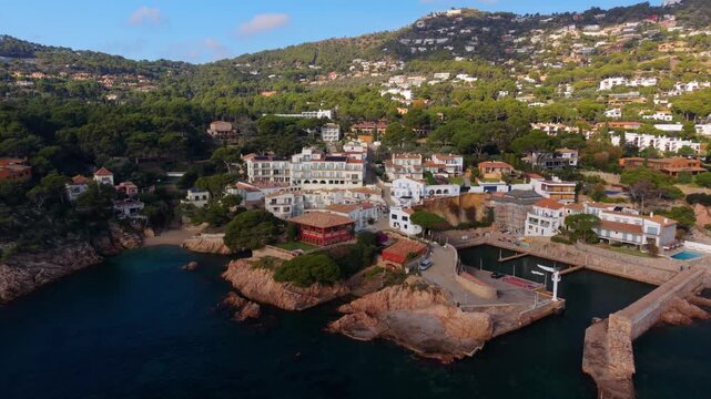 Beautiful aerial view of fornells harbor and white houses along the rugged costa brava coast in catalonia, with turquoise waters, sandy coves and sunlit seaside scenery