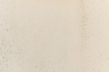 abstract background of on old embossed plastered wall painted beige close up