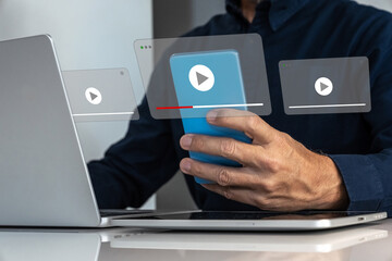 Man Watching or Managing Multiple Digital Video Streams on a Smartphone and Laptop, Highlighting...