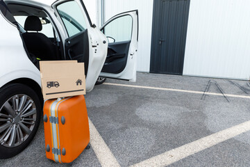 suitcases and boxes were lying on the ground next to the car.