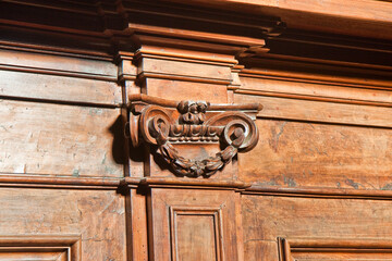 Detail of an old carved italian wooden furniture with floral elements just restored
