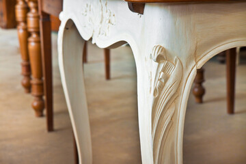Detail of an old carved italian wooden table with floral elements just restored