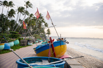 Vietnam traditional basket boats with flags on tropical beach